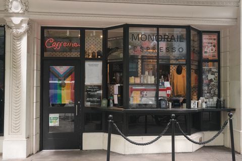 Photo of the hole in the wall coffee shop Monorail espresso witha  big pride flag in Seattle.