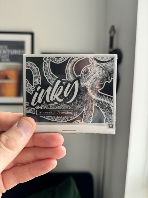 Photo of the front of the pimoroni eink hat for raspberry pi. The eink screen has a gorgeous octopus illustration on it.