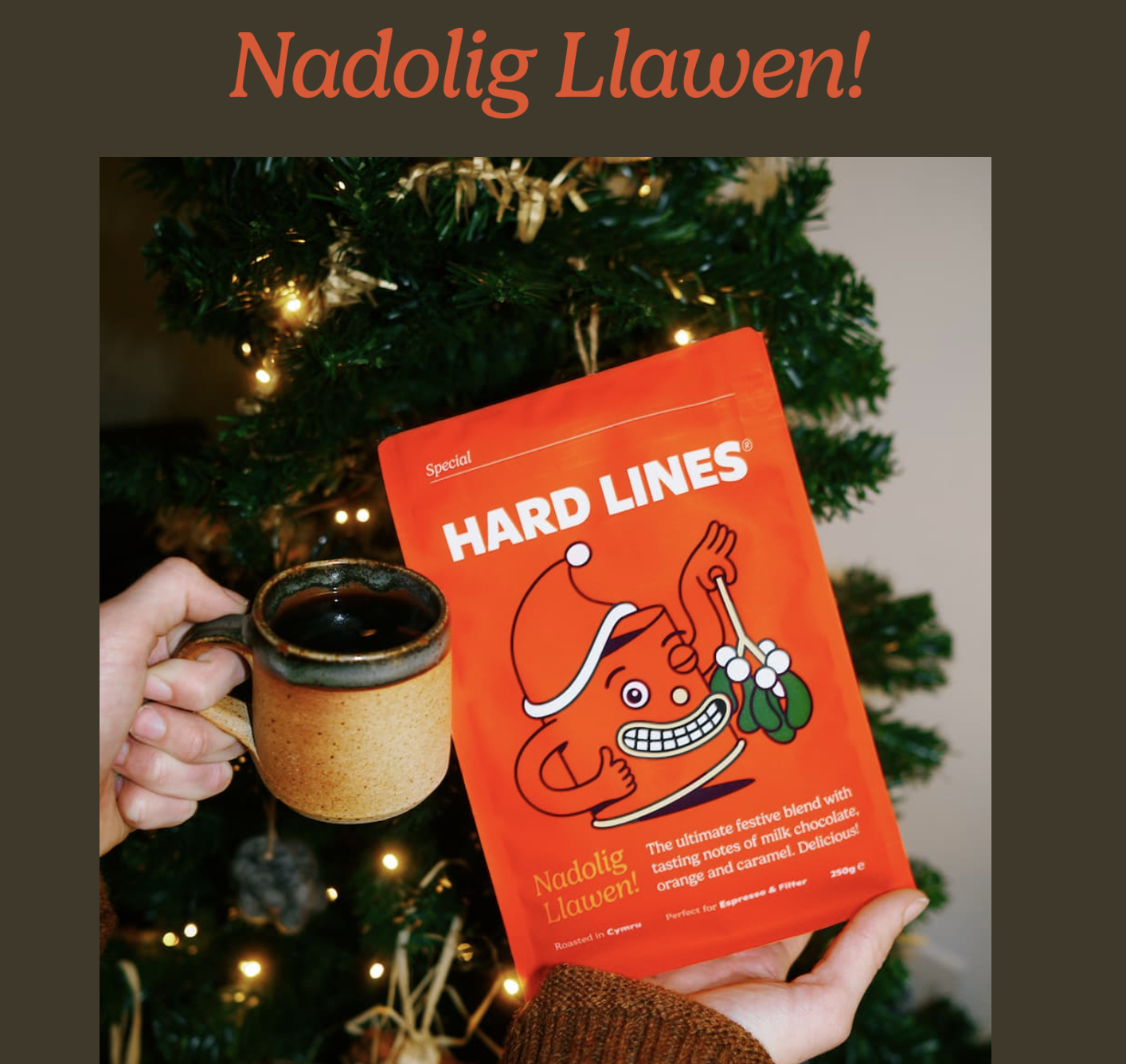 An image from of the announcement of Hard Lines' Christmas coffee. Declaring "Nadolig Llawen!" Which means "Merry Christmas" in welsh. The coffee is bright red with an anthropomorphic grinning coffee mug holding mistletoe on the packaging